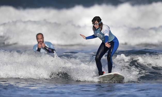 Carmen Lopez Garcia, Spain's first blind female surfer who is to participate in the ISA World Adaptive Surfing Championship, is watched by her coach Lucas Garcia during training at Salinas beach, Spain, December 6, 2018. REUTERS/Eloy Alonso
