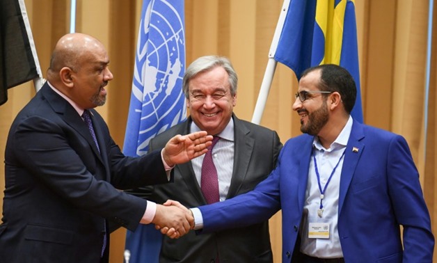 Yemen's foreign minister and the chief rebel negotiator shook hands watched by UN Secretary General Antonio Guterres
