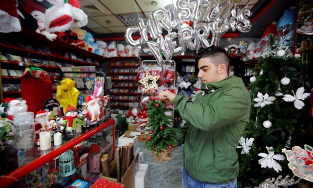 A Palestinian vendor holds a Christmas gift in a shop in Bethlehem in the occupied West Bank November 28, 2018. REUTERS/Mussa Qawasma
