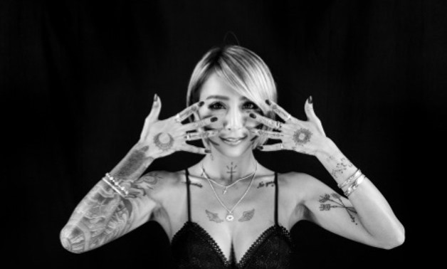 Former porn star Izumi turns heads with her bleach-blonde bob and an array of designs inked across half of her body Former porn star Izumi turns heads with her bleach-blonde bob and an array of designs inked across half of her body AFP
