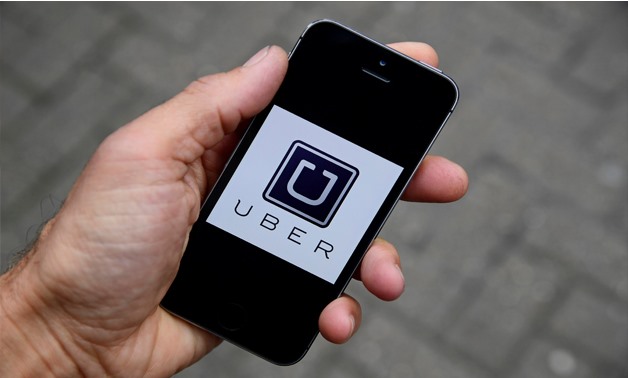 Photo illustration shows the Uber app logo displayed on a mobile telephone, as it is held up for a posed photograph - REUTERS/Toby Melville