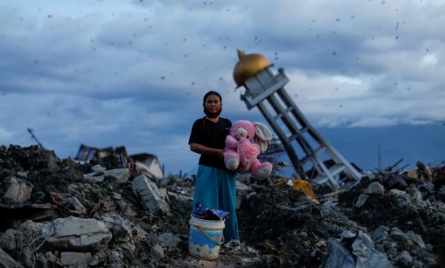 A woman holds a stuffed rabbit toy after it was found at her destroyed home where she said she had lost her three children, in Palu, Central Sulawesi, Indonesia, October 7, 2018. REUTERS/Jorge Silva.