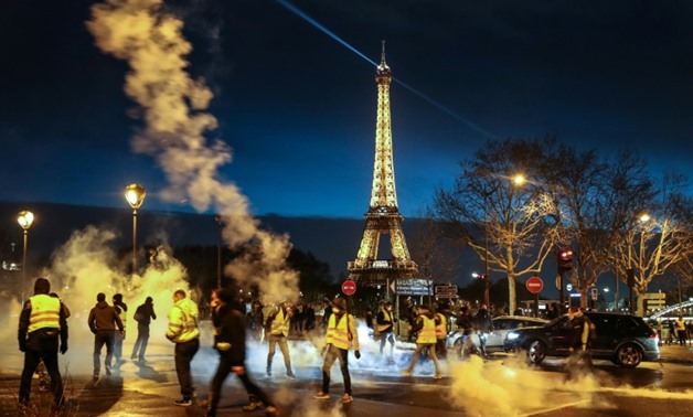 "Yellow Vest" protesters demonstrate for a sixth Saturday of protests, with the Eiffel Tower in the background.