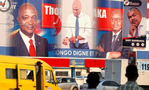 A signs rotates between pictures of presidential candidates Emmanuel Ramazani Shadary, former Congolese Interior Minister (L) and Martin Fayulu, Congolese joint opposition (C) in Kinshasa, Democratic Republic of Congo, December 22, 2018. REUTERS/Baz Ratne