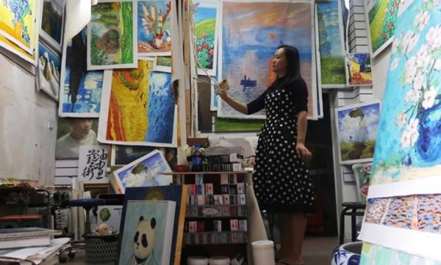 The 32-year old Chinese artist is actually handling a 1,000 yuan ($145) reproduction she made in one day from an image on her cell phone, not Van Gogh’s masterpiece that is estimated to be worth over $100 million.