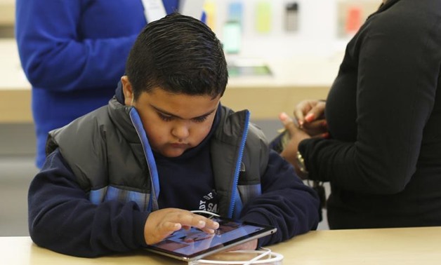 A child uses an iPad Air tablet at the Apple store in San Francisco, California November 1, 2013. REUTERS/Stephen Lam