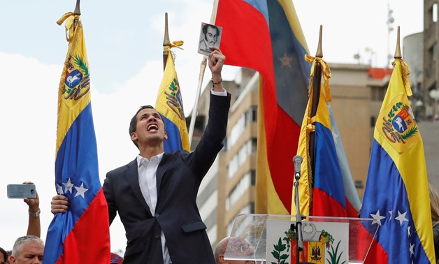 Juan Guaido, President of Venezuela's National Assembly, holds a copy of Venezuelan constitution during a rally against Venezuelan President Nicolas Maduro's government and to commemorate the 61st anniversary of the end of the dictatorship of Marcos Perez