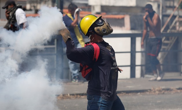 A demonstrator throws back a tear gas canister during a protest against Venezuelan President Nicolas Maduro's government in Caracas, Venezuela January 23, 2019. REUTERS/Manaure Quintero NO RESALES. NO ARCHIVES.

