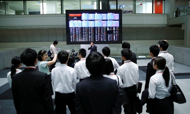 FILE PHOTO - Visitors look at an electronic stock quotation board at the TSE in Tokyo - Reuters. 