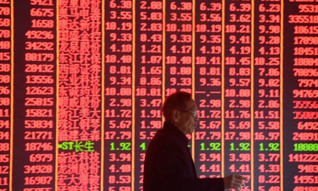 A man is seen in front of an electronic board showing stock information on the first day of trading in the Year of the Pig, following the Chinese Lunar New Year holiday, at a brokerage house in Hangzhou, Zhejiang province, China February 11, 2019. REUTERS