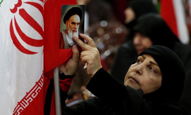 A Hezbollah supporter attaches portrait of Ayatollah Khomeini, during a rally to commemorate the 40th anniversary of Iran’s revolution, in southern Beirut, Lebanon, Wednesday, Feb. 6, 2019. (AP/Hussein Malla)