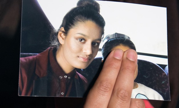 Laura Lean / AFP | In this file photo taken on February 22, 2015 Renu Begum, eldest sister of Shamima Begum, holds a picture of her sister while being interviewed by the media in central London.
