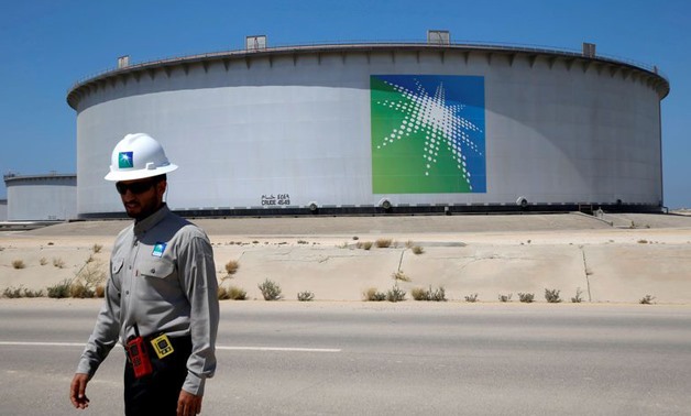 An Aramco employee walks near an oil tank at Saudi Aramco's Ras Tanura oil refinery and oil terminal in Saudi Arabia May 21, 2018. REUTERS/Ahmed Jadallah/File Photo