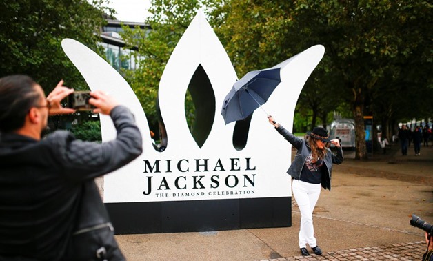 A fan has her photograph taken next to a Giant Crown installed to celebrate the diamond birthday of Michael Jackson, on the South Bank in London, Britain August 29, 2018. REUTERS/Henry Nicholls/File Photo