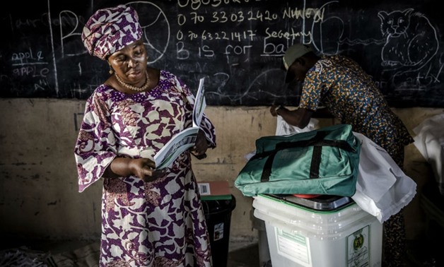 Luis Tato, AFP | An electoral commission official checks an electoral manual while ballot boxes and other voting material arrive at a polling station in Yola, Nigeria Feb. 22, 2019.
