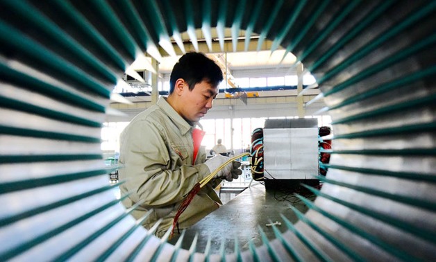 A man works on electric machine parts at a workshop of an equipment manufacturing company in Weifang, Shandong province, China October 31, 2018. China Daily via REUTERS
