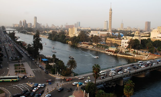 Cars crisscross through the inner city of Cairo Egypt, alongside the Nile River during the day. Cairo is the capital of Egypt and the largest city in Africa as well as one of the most densely populated cities in the world. Cairo is the center of the regio