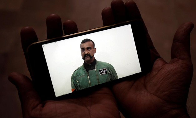 A man watches a statement of Indian Air Force pilot Abhinandan Varthaman on his mobile phone, released on Twitter by the Ministry of Information & Broadcasting, in Karachi, Pakistan March 1, 2019. REUTERS/Akhtar Soomro