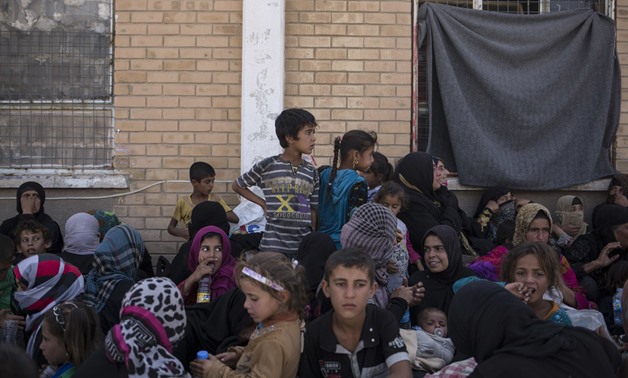 Women and children sit outside a Kurdish screening center to determine if they are associated with Daesh in this October 3, 2017 photo taken in Dibis, Iraq. (AP)

