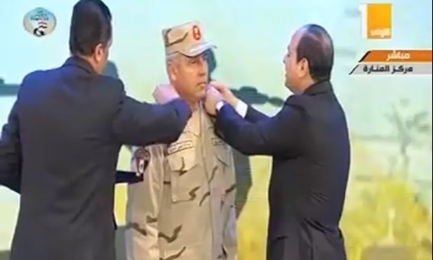 President Abdel Fatah al-Sisi changes shoulder marks for Chairman of the Armed Forces Engineering Authority Kamel Al-Wazir after he had promoted him to Lieutenant General from Major General during the celebration held in the occasion of ‘Martyr Day’ marki