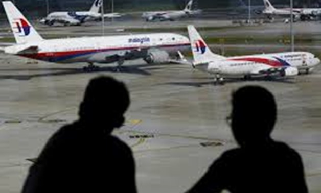 FILE PHOTO: Men watch Malaysia Airlines aircraft at Kuala Lumpur International Airport in Sepang, Malaysia, in this picture taken March 2, 2016. REUTERS/Olivia Harris/File Photo