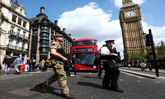 A soldier and an armed policeman pass Big Ben in London, Britain May 24, 2017. REUTERS/Neil Hall