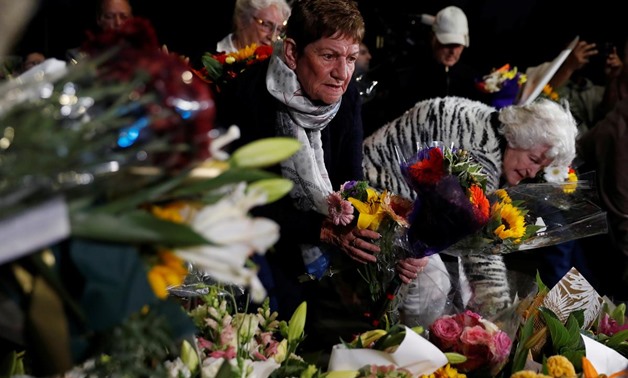 People move the flowers after police removed a police line, outside Masjid Al Noor in Christchurch, New Zealand, March 16, 2019. REUTERS