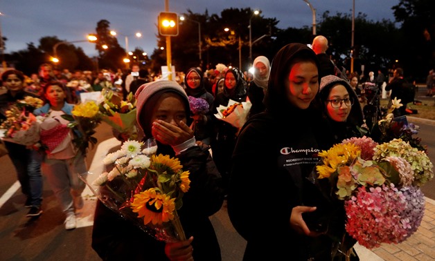 People reacts as they move the flowers after police removed a police line, outside Masjid Al Noor in Christchurch, New Zealand, March 16, 2019. REUTERS/Jorge Silva TPX IMAGES OF THE DAY

