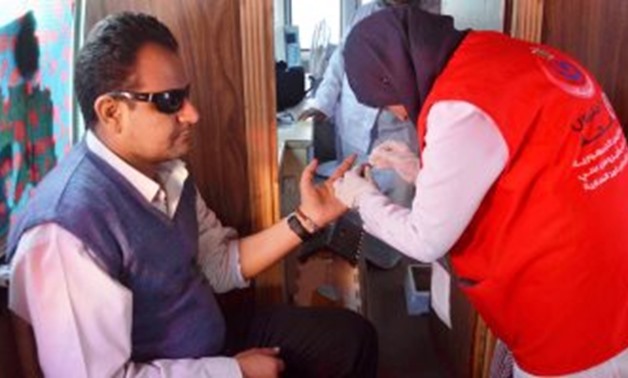 FILE - A doctor getting a blood sample of a citizen within "100 Million Healthy Lives" campaign targeting to screen Egyptians for Hepatitis C and provide free treatment 