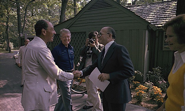 FILE - Anwar Sadat and Menachem Begin shake hands as Jimmy Anwar Sadat and Menachem Begin greet each for their first meeting at the Camp David Summit as Jimmy Carter and Rosalynn Carter watch, 1978 - Courtesy of Jimmy Carter Library - Handout Via Reuters