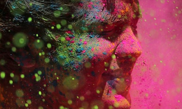 A man daubed in colours reacts as colour powder is thrown towards him during Holi celebrations in Mumbai, India, March 21, 2019. REUTERS/Francis Mascarenhas.