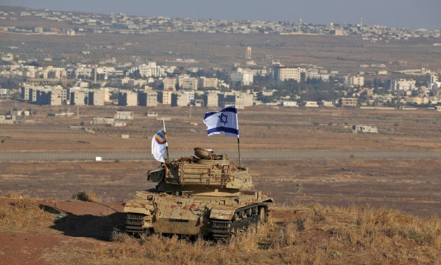 An Israeli flag flutters over the wreckage of an Israeli tank overlooking the armistice line on the Golan Heights.