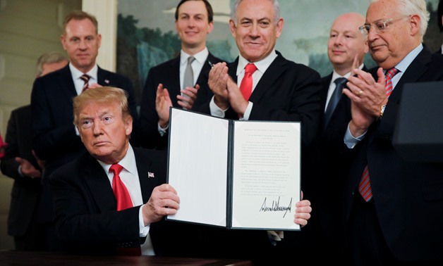 U.S. President Donald Trump holds a proclamation recognizing Israel's sovereignty over the Golan Heights as he is applauded by Israel's Prime Minister Benjamin Netanyahu and others during a ceremony to in the Diplomatic Reception Room at the White House i