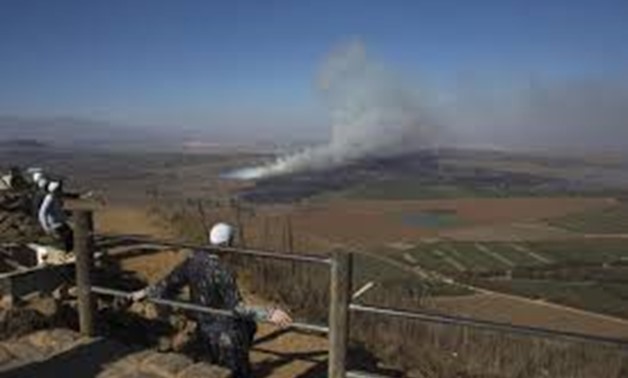 Druze men look at smoke rising on the Israeli-controlled side of the line dividing the Israeli-occupied Golan Heights from Syria following fighting near the Quneitra border crossing, August 27, 2014. REUTERS/Ronen Zvulun

