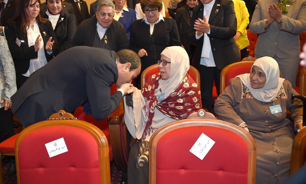 President Abdel Fatah al-Sisi kisses hand of an ideal mother on the Egyptian  Woman Day-Press photo