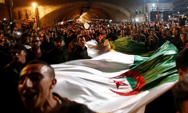 People carry a national flag as they celebrate on the streets after Algeria's President Abdelaziz Bouteflika has submitted his resignation, in Algiers, Algeria April 2, 2019. REUTERS/Ramzi Boudina
