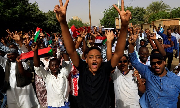 A Sudanese demonstrator flashes a two finger salute as they attend a protest rally demanding Sudanese President Omar Al-Bashir to step down outside the Defence Ministry in Khartoum, Sudan April 11, 2019. REUTERS/Stringer