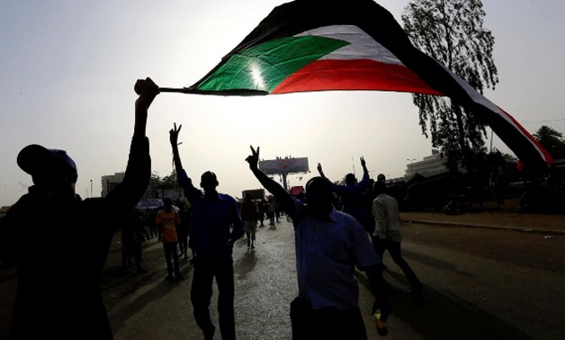 Sudanese demonstrators wave their national flag as they arrive for a protest rally demanding Sudanese President Omar Al-Bashir to step down outside the Defence Ministry in Khartoum, Sudan April 11, 2019. REUTERS/Stringer