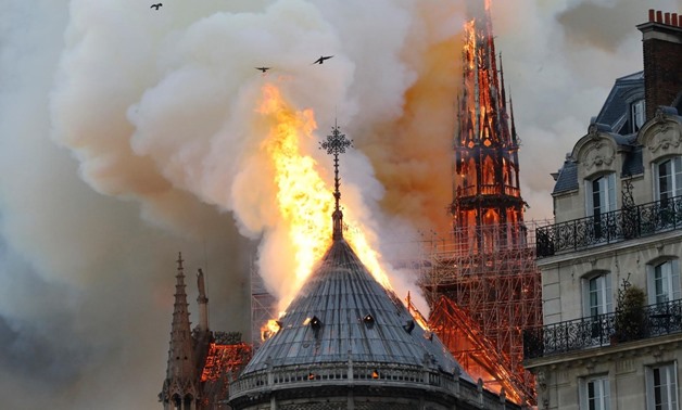 Smoke billows as fire engulfs the spire of Notre Dame Cathedral in Paris, France April 15, 2019. REUTERS/Benoit Tessier
