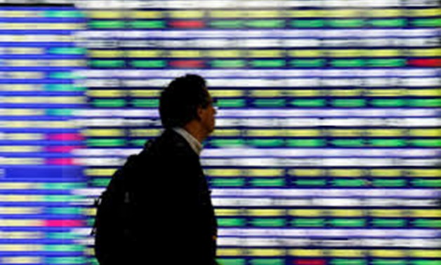 FILE PHOTO: A man walks past an electronic stock quotation board outside a brokerage in Tokyo, Japan, November 13, 2018. REUTERS/Toru Hanai/File Photo
