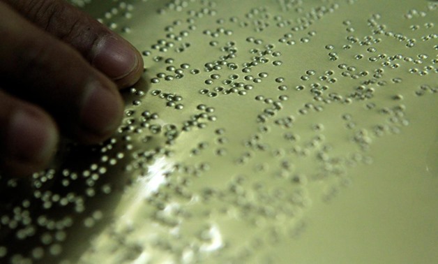FILE – Person’s hand reading braille language - Reuters