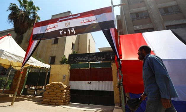 An Egyptian man walks in front of a school used as a polling station covered from outside by Egyptian flags, during the preparations for the upcoming referendum on constitutional amendments in Cairo, Egypt April 18, 2019. REUTERS/Amr Abdallah Dalsh
