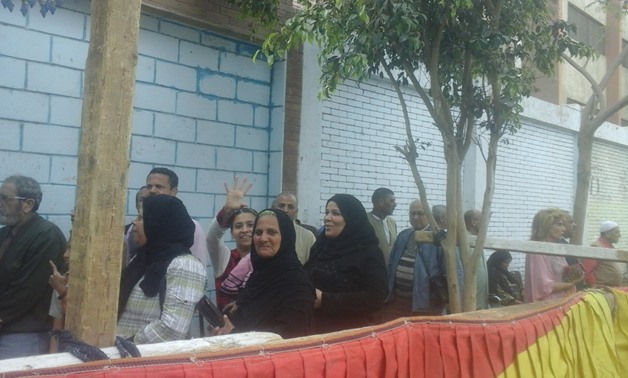 Queues of voters lined up outside polling stations in Giza to vote in referendum - Press Photo