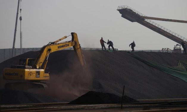 Labors work on a pile of iron ore at a steel factory in Tangshan - REUTERS/Kim Kyung-Hoon