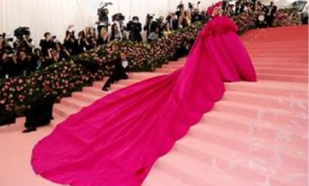 Pop superstar Lady Gaga made a grand entrance at New York's annual Met Gala on Monday, wearing a voluminous bright pink dress that she shed on the red carpet to reveal three other outfits layered underneath, including a bra and underwear, her interpretati