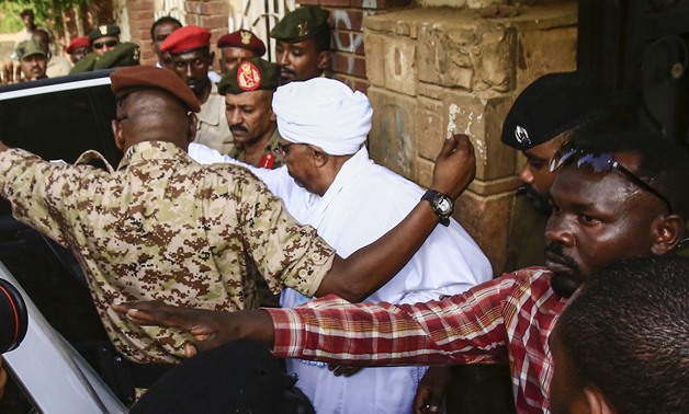 Sudan's ousted president Omar al-Bashir (C) is escorted into a vehicle as he returns to prison following his appearance before prosecutors over charges of corruption and illegal possession of foreign currency, in the capital Khartoum on June 16, 2019. Bas