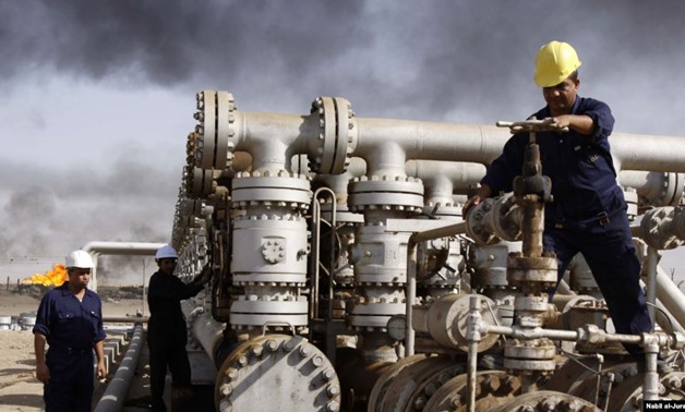 FILE - In this Dec. 13, 2009 file photo, Iraqi workers are seen at the Rumaila oil refinery, near the city of Basra, 340 miles (550 kilometers) southeast of Baghdad, Iraq.
