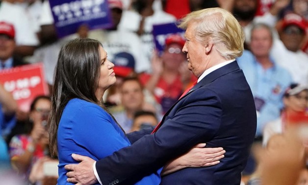 U.S. President Donald Trump and press secretary Sarah Sanders hug at a campaign kick off rally at the Amway Center in Orlando, Florida, U.S., June 18, 2019. REUTERS/Carlo Allegri

