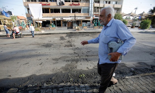 An Iraqi man walks past the site of a car bomb exploded near a cafe in Baghdad. May 30, 2017. REUTERS/Khalid al-Mousily

