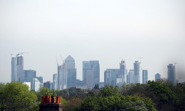 FILE PHOTO: The Canary Wharf financial district is seen above a residential rooftop in London, Britain, May 7, 2019. REUTERS/Hannah McKay/File Photo
